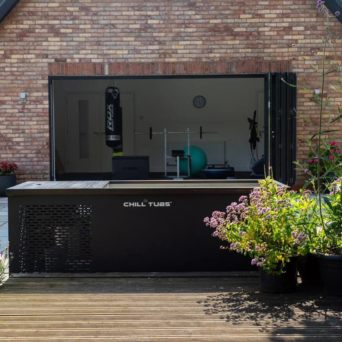 Original cold plunge outside a home gym beside a timber deck