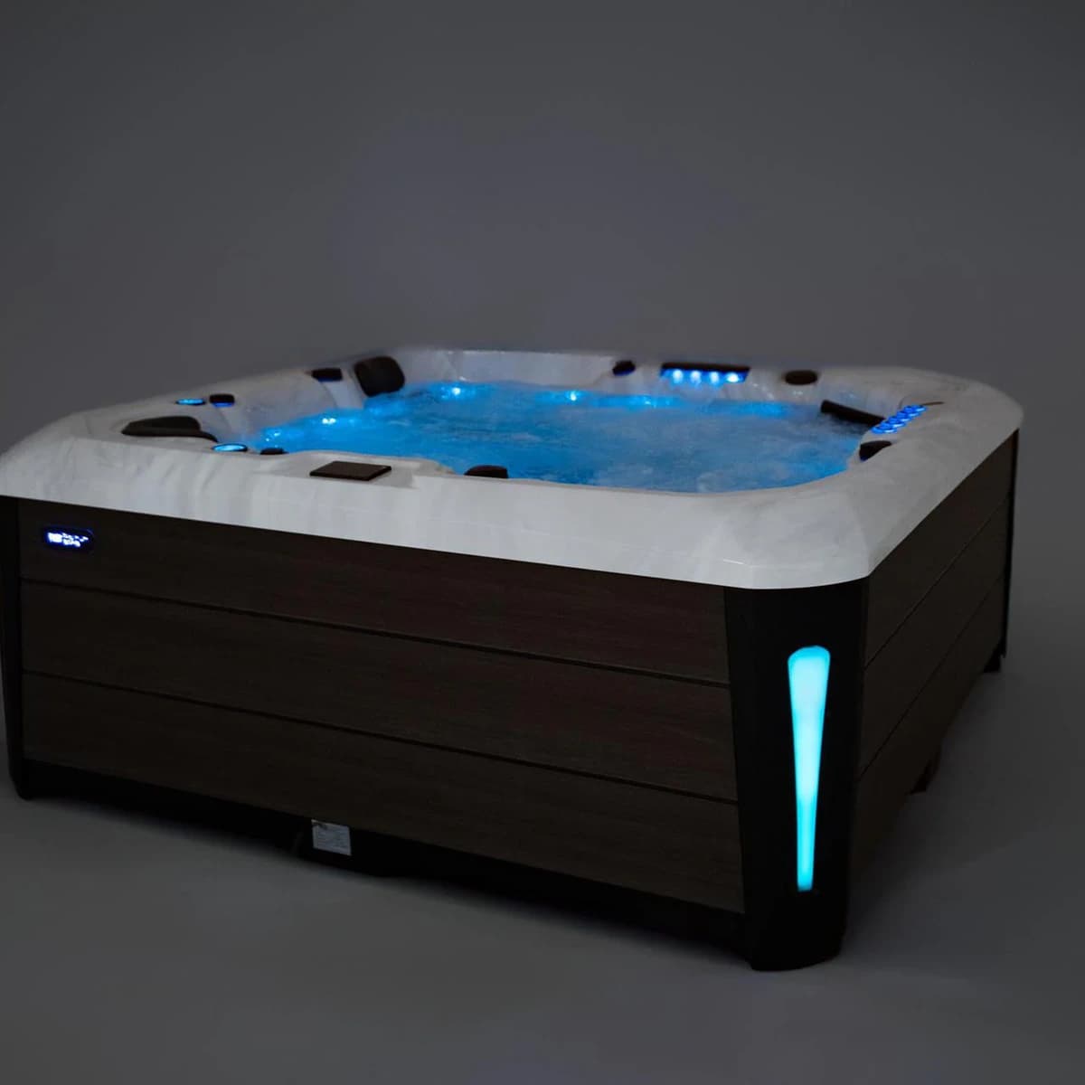 Platinum Spas Barcelona hot tub with blue-lit water and corner lights, side angle