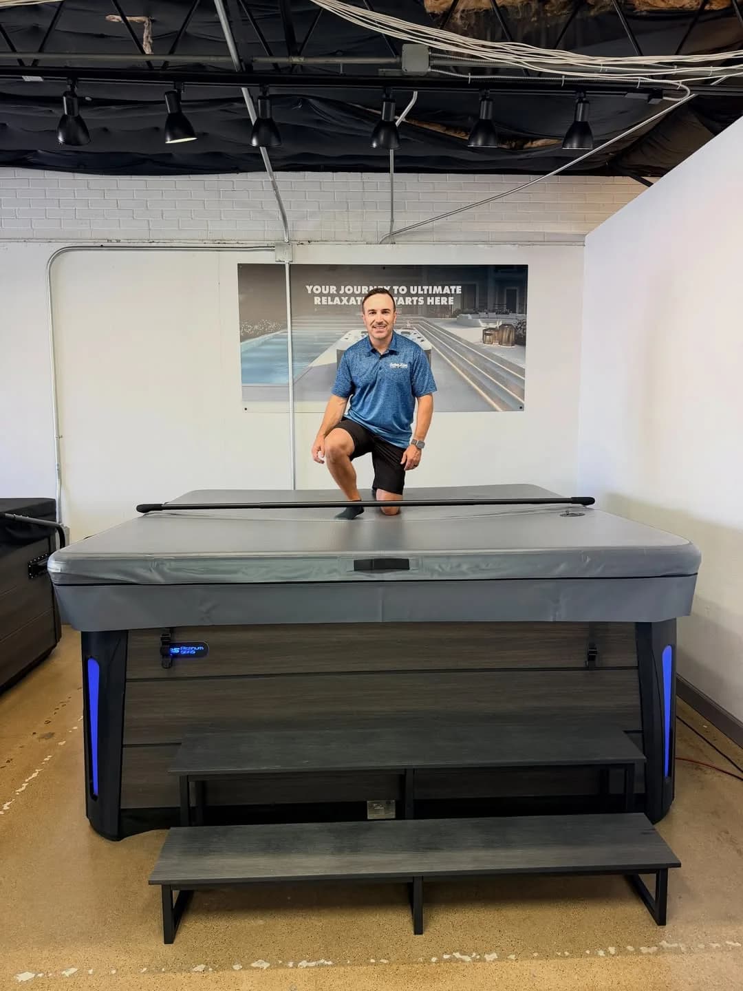 Southern Leisure employee demonstrating an Aircap hot tub cover in the showroom