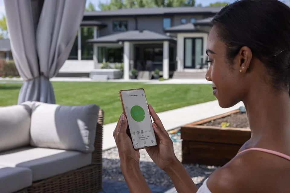 Bullfrog manufacturer photograph of a spa owner viewing the spa controls on a phone