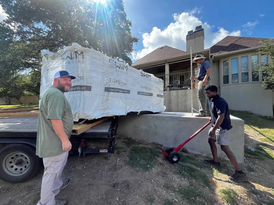 Southern Leisure crew unloading a wrapped S150 swim spa beside a San Antonio patio