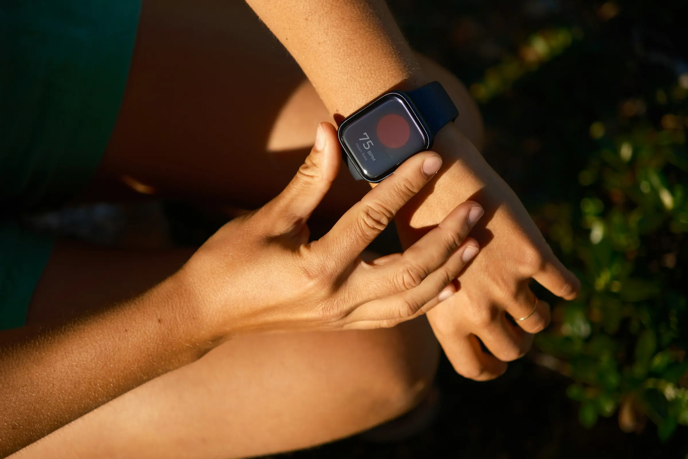A hand checking heart rate on a smartwatch after a sauna session