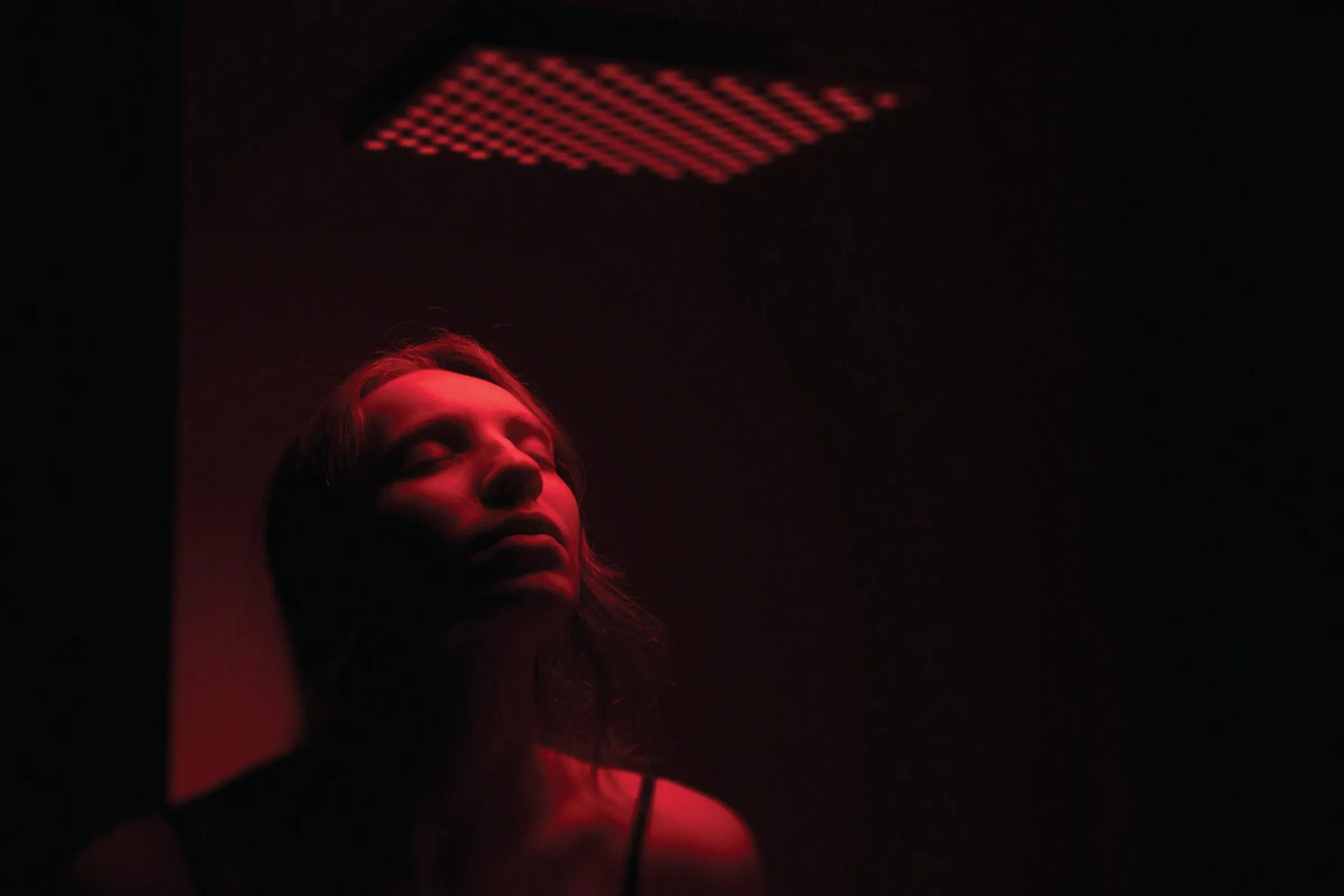 A woman relaxing under the glow of an infrared sauna
