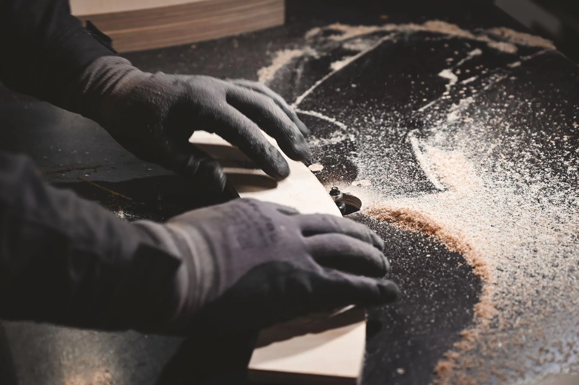 A craftsman sanding a timber board in the Hekla workshop
