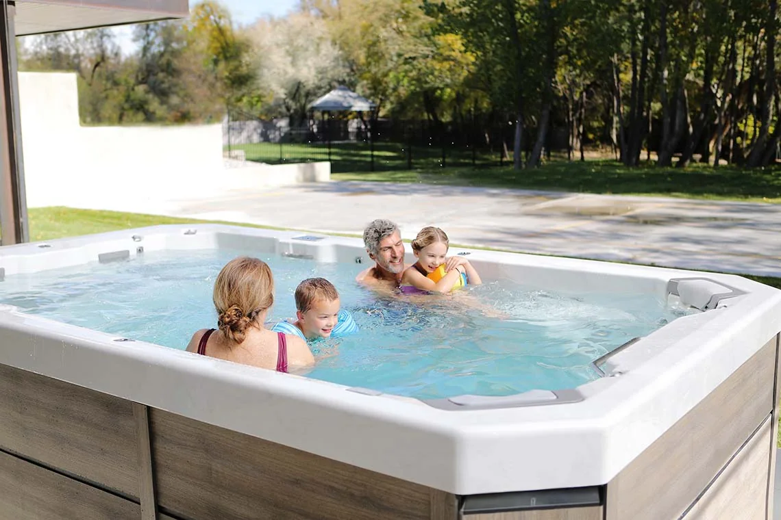 Family using a Bullfrog Spas swim spa outdoors