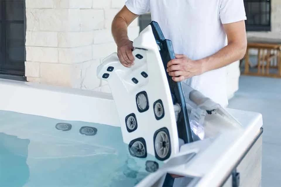 Bullfrog JetPak massage unit being positioned in a hot tub seat