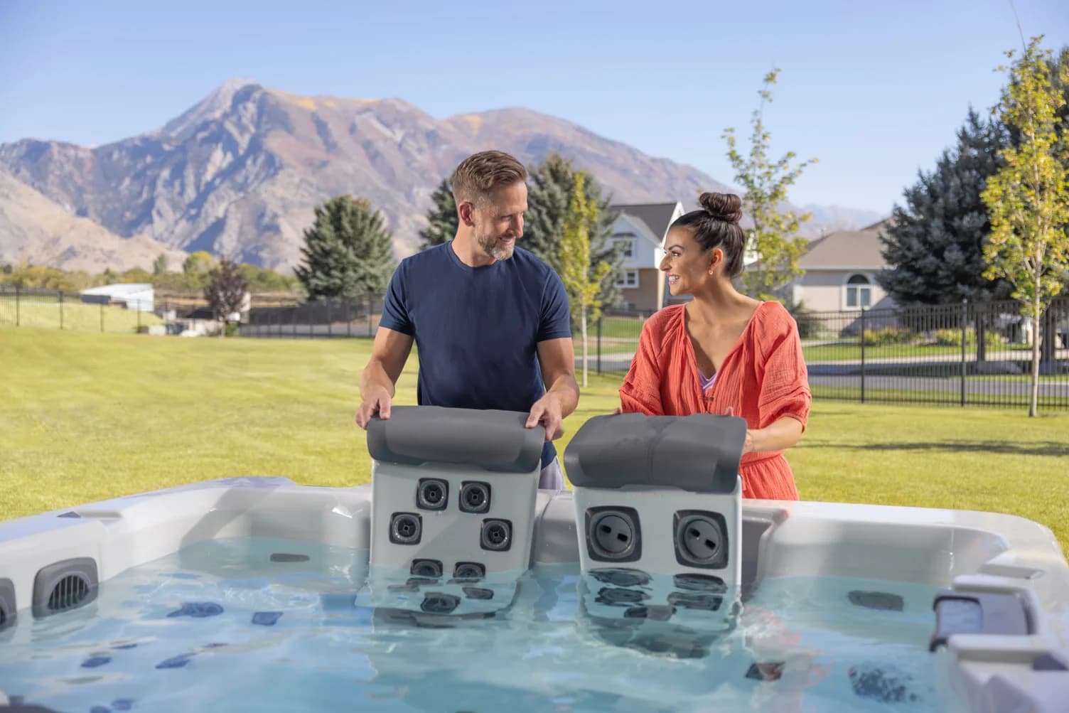 Two people compare movable JetPak seats in a Bullfrog hot tub
