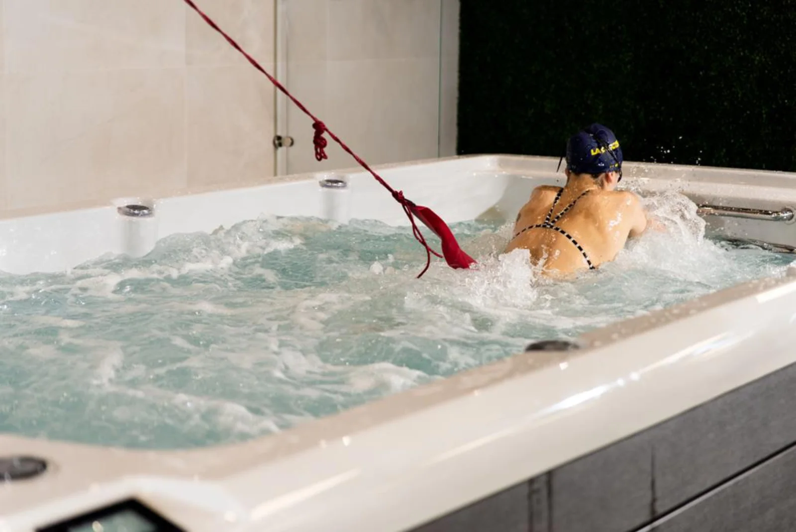 Swimmer training with resistance bands in a Platinum Spas Helios swim spa