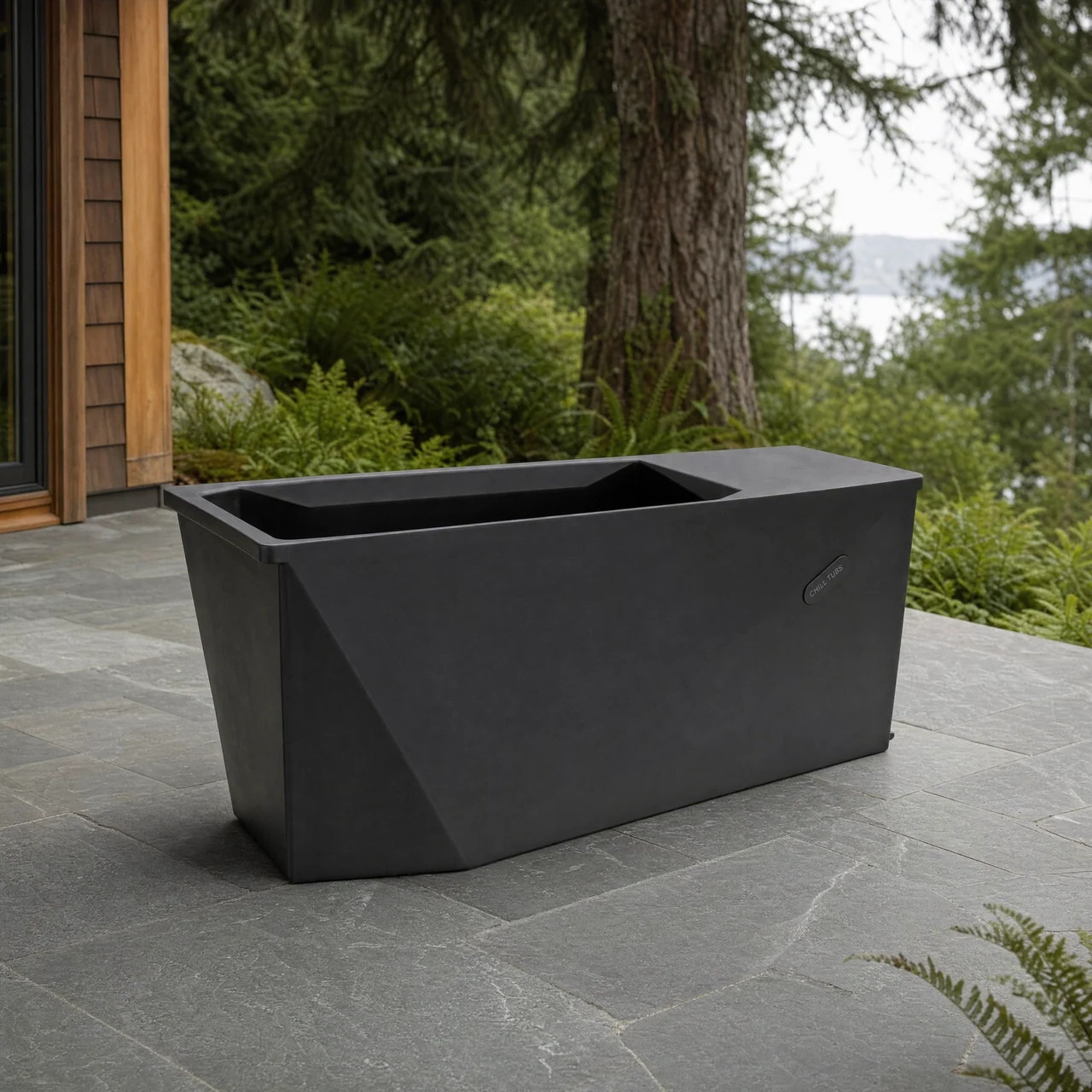 Chill Tubs Lite shown from the bath end on a stone terrace beside a cedar home.
